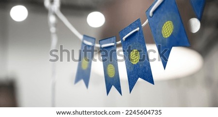 A garland of Commonwealth national flags on an abstract blurred background.