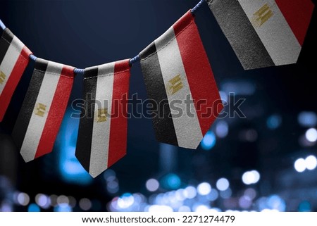 A garland of Egypt national flags on an abstract blurred background.