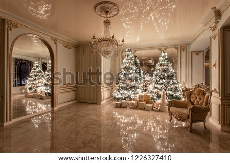 Garland light bulbs. Christmas evening. classic luxurious apartments with decorated christmas tree. Living hall large mirror, chair, high windows, columns and stucco.