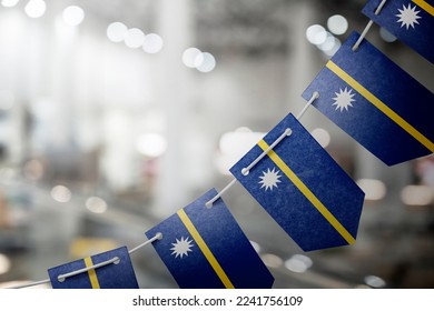 A garland of Nauru national flags on an abstract blurred background. - Shutterstock ID 2241756109