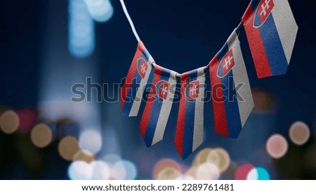 A garland of Slovakia national flags on an abstract blurred background.