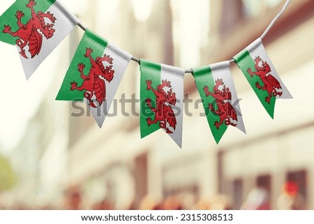A garland of Wales national flags on an abstract blurred background.