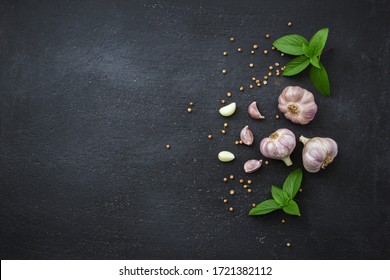 Garlic With Basil Leaf And Coriander Seed On Black Background.