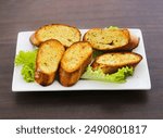 Garlic bread (also called garlic toast)[1] consists of bread (usually a baguette, sour dough, or bread such as ciabatta), topped with garlic and occasionally olive oil or butter and may include additi