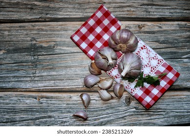 Garlic bulbs and clove of garlic with a checkered napkin on a wooden table. - Powered by Shutterstock