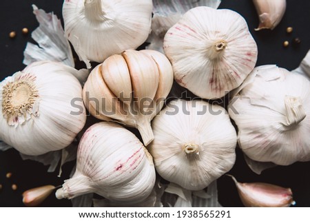 
Garlic bulbs on black background, close-up. Organic garlic top view. Food background. Selective focus.