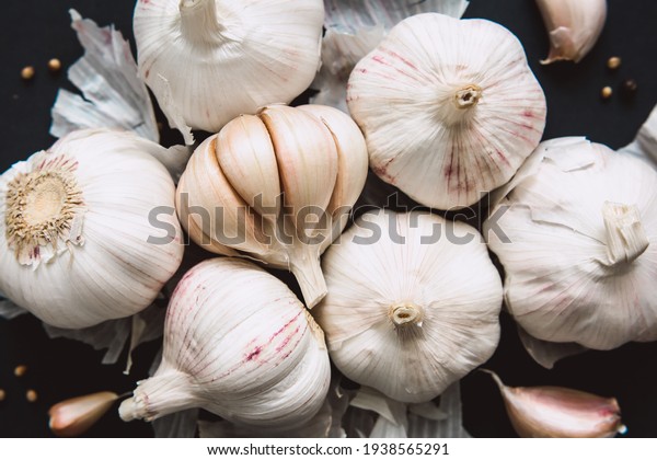 \
Garlic bulbs on black\
background, close-up. Organic garlic top view. Food background.\
Selective focus.