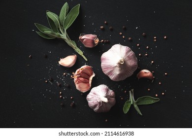 Garlic bulbs, spices, herbs and garlic cloves on a black background. Close-up, flat lay, top view. Food background, selective focus.  - Powered by Shutterstock