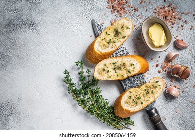 Garlic butter on Toasted Baguette bread with Salt, Pepper, Thyme and Olive. White background. Top view. Copy space