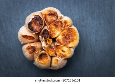 Garlic clove grilled on black stone background; top view. - Shutterstock ID 2071836101