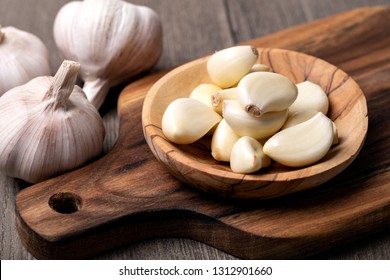 Garlic Cloves and Bulb in vintage wooden bowl - Shutterstock ID 1312901660