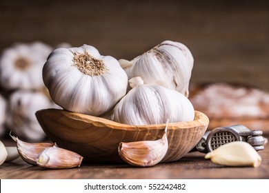 Garlic Cloves and Bulb in vintage wooden bowl. - Shutterstock ID 552242482