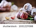 Garlic cloves on rustic table in wooden bowl. Fresh peeled garlics and  bulbs.