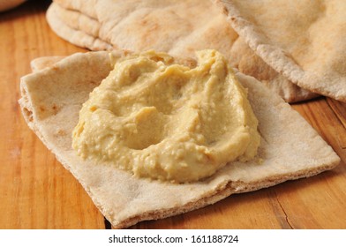 Garlic Hummus On A Wedge Of Pita Bread On A Rustic Wood Table