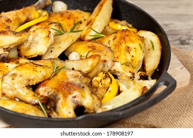 Garlic, Lemon And Rosemary Roasted Chicken On Frying Pan With Potato. Selective Focus.