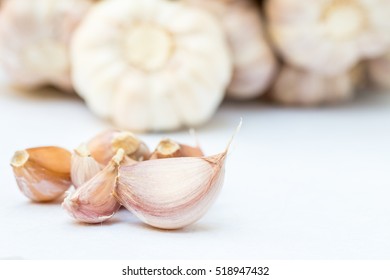 Garlic lobes, with bunch of garlic blurred background.