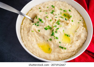 Garlic Mashed Potatoes In A Serving Bowl: A Large Bowl Of Whipped Potatoes Topped With Chives And Melted Butter