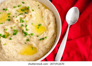 Garlic Mashed Potatoes In A Serving Bowl: A Large Bowl Of Whipped Potatoes Topped With Chives And Melted Butter