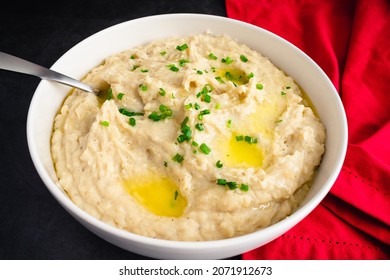 Garlic Mashed Potatoes In A Serving Bowl: A Large Bowl Of Whipped Potatoes Topped With Chives And Melted Butter