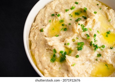 Garlic Mashed Potatoes In A Serving Bowl: A Large Bowl Of Whipped Potatoes Topped With Chives And Melted Butter