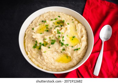 Garlic Mashed Potatoes In A Serving Bowl: A Large Bowl Of Whipped Potatoes Topped With Chives And Melted Butter