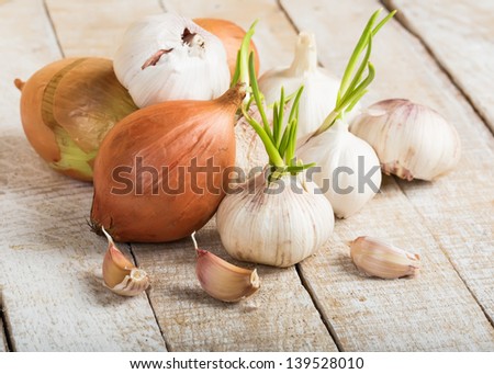 Garlic and onion on wooden background. Selective focus.