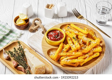garlic parmesan polenta fries with parmesan cheese, thyme and spices in a bamboo dish with tomato sauce on a white wooden table, italy cuisine