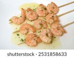 Garlic prawn skewer with olive oil on white background