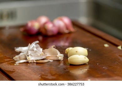 garlic and shallots on wood chopping block