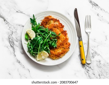 Garlicky bread crumbs crispy turkey chop and fresh lemon arugula salad on a light background, top view    - Shutterstock ID 2083700647