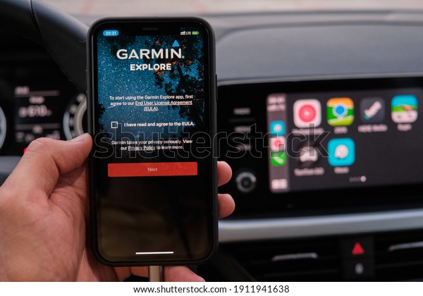 Garmin\
explore logo on the screen of smart phone in mans hand on the\
background of car dashboard screen with application of navigation\
or maps. January 2021, Prague, Czech Republic.\
