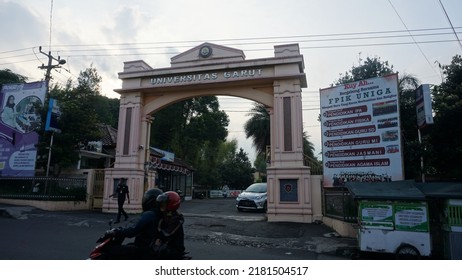 Garut, Indonesia - July 19th 2022 : The View Of The Gates Of The Garut University Campus, The Afternoon Atmosphere, It Can Be Seen Vehicles Going Back And Forth And Street Vendors' Carts And Billboard