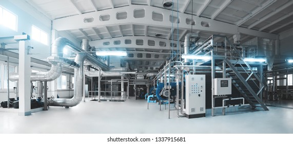 Gas boiler, control cabinet and pipes for the supply of gas and steam. Panoramic view of boiler room. Blue toning