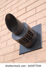 Gas boiler flue outlet on exterior wall of a modern building in the UK.