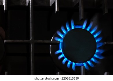 Gas Burner With A Blue Flame On A Black Kitchen Stove, Top View, Selective Soft Focus, Copy Space. Gas Crisis.