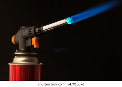 gas burner - burning tool with a blue flame. low key - Powered by Shutterstock