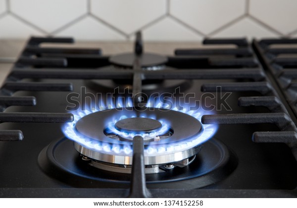 Gas burner on black modern\
kitchen stove. kitchen gas cooker with burning fire propane\
gas