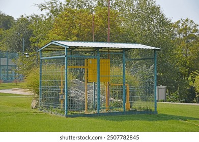 gas cabinet in the city park. valves and control panel are covered with mesh and fence to prevent unauthorized access - Powered by Shutterstock