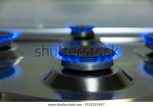 Gas\
flame, burning gas stove burner on the kitchen\
table.