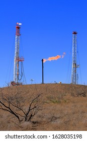 Gas Flare Between Two Drilling Rigs In The West Texas Oil Field