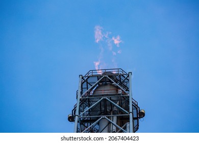 Gas flare is releasing and burning to the atmosphere at an offshore gas platform with sky. Fire on a stack of flare at oil and gas central processing platform. A gas flare at an oil refinery.
