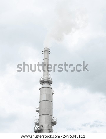 Gas flare or flare stack with clouds of exhaust fumes under overcast sky from crude oil refinery plant in San Antonio, Texas, major source of air pollutants part of refined petroleum products. USA