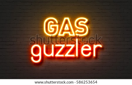 Gas guzzler neon sign on brick wall background