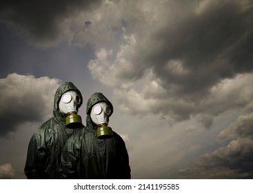 Gas masks. Two people with gas masks and dramatic sky behind with copy space. Danger of chemical weapon.