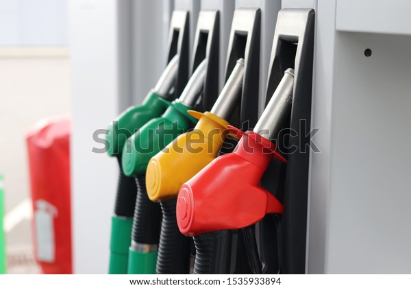 Gas and petrol station. Guns for refueling at a\
gas station. Petrol pump different colors in gas station. Сolorful\
fuel pistols on fuel\
station.
