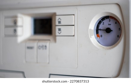 Gas pressure meter on the panel of the heating gas boiler. Symbolic image of the heating season at home. Dial and pressure gauge on combi boiler. Hot water and heating. Boiler accessories