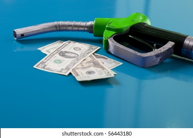 Gas price concept. American dollars and fuel nozzle