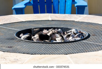 Gas Or Propane Powered Firepit With White Hot Coals And Rocks And Relaxing Chair