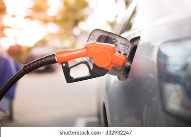 Gas Pump Nozzle In The Fuel Tank Of A Bronze Car, Refuel