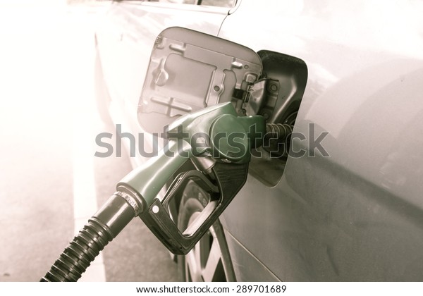 Gas pump nozzle in the fuel tank of dust\
car,vintage filter